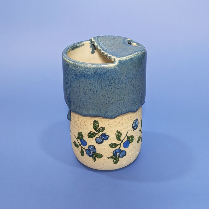 A rear side view showing the scalloped lid design.