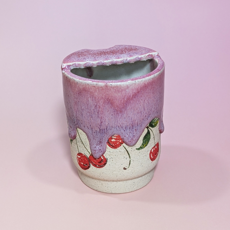 The back of the sippy cup shows waves drips cascading over the cherries.