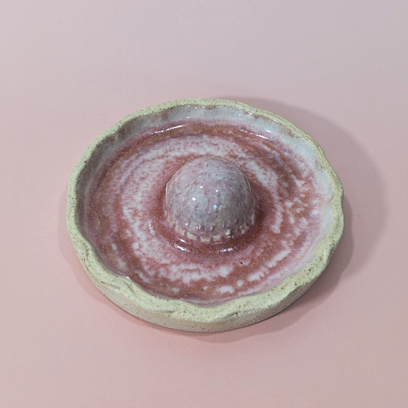 Shows the scalloped shaped rim of the trinket dish with a sculpted strawberry in the center.