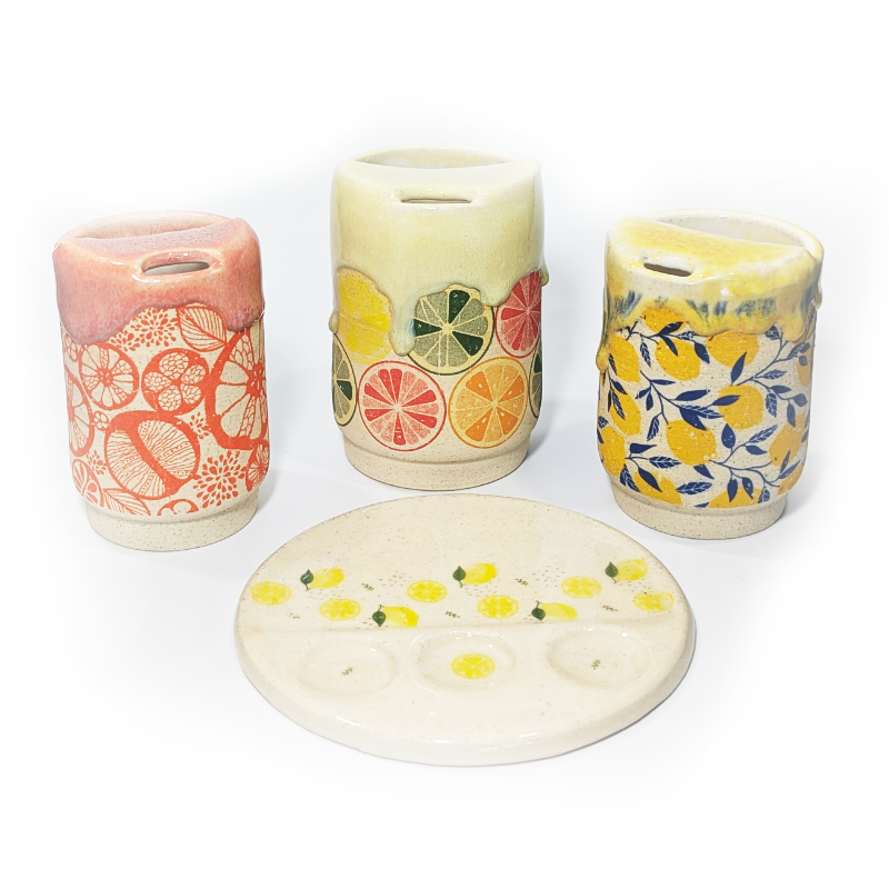Citrus themed ceramic sippy cups with a variety of colorful citrus patterns and a lemon paint pallet