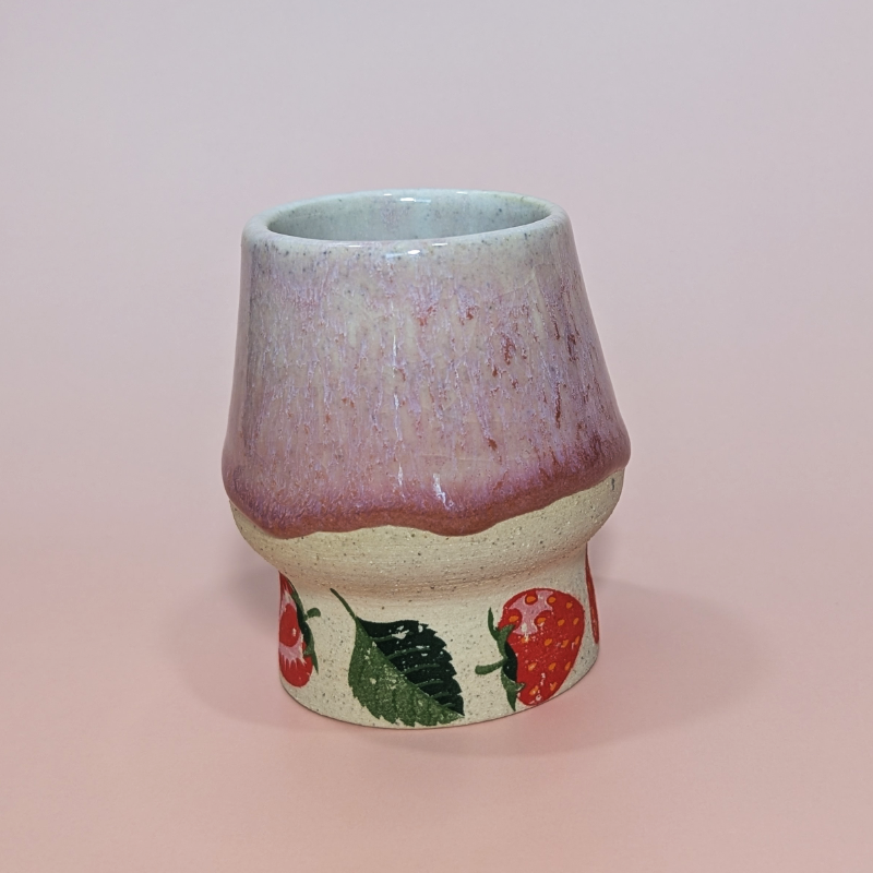 Another angle showing strawberries and leaves at the base of the cup. The pattern wraps around the cup.