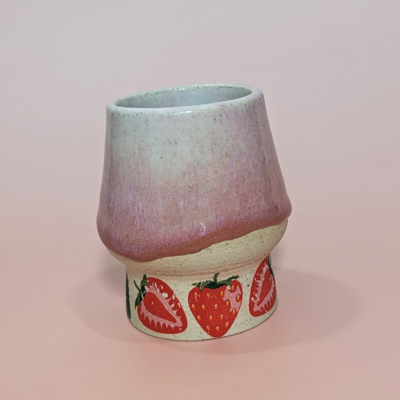 This picture shows three strawberries in a row at the base of the cup and the natural flow of the glaze.