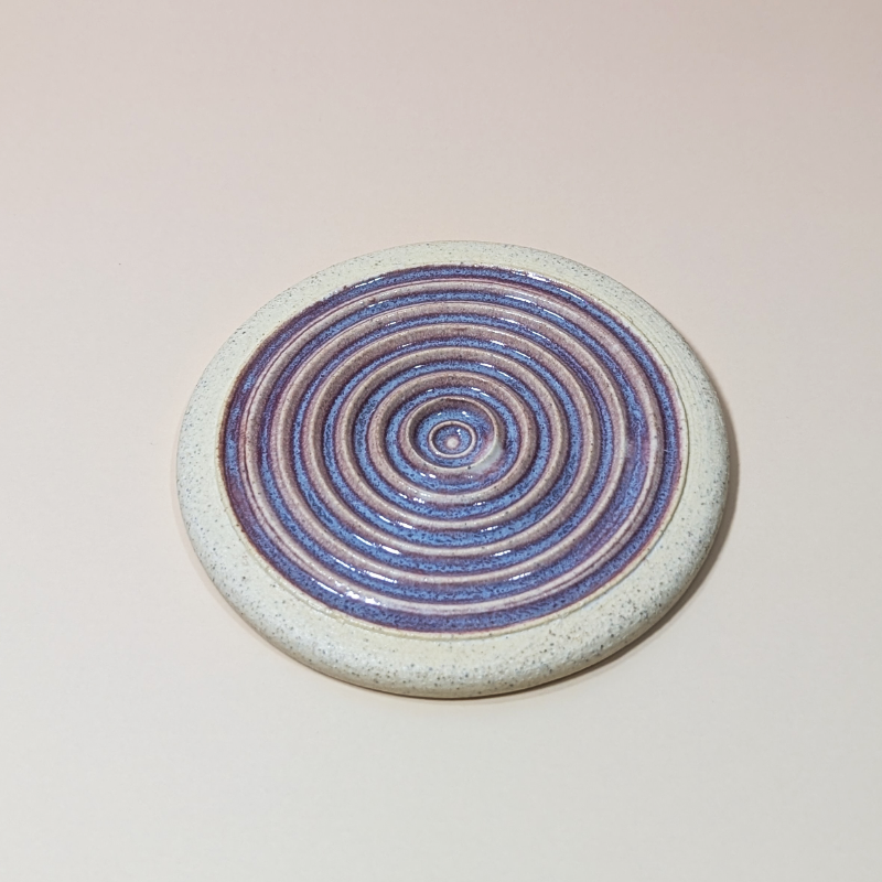 A slightly angled view of the garlic grater showing the sharp ridges used for grating garlic.