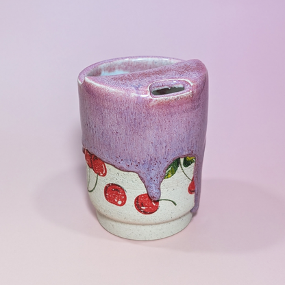 Another front view from a slight angle showing the cherry and leaf design being covered by the glaze.