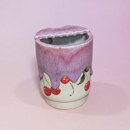 The back of the sippy cup shows waves drips cascading over the cherries.