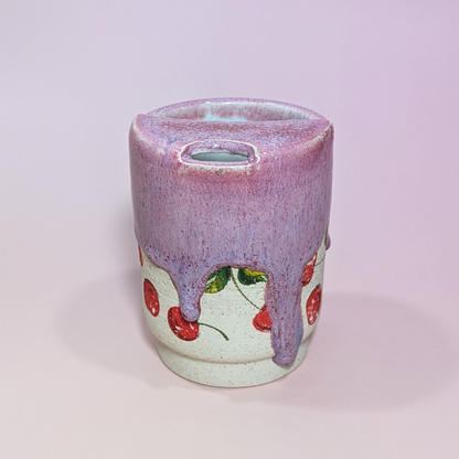 The front of a cherry sippy cup with showcasing the long drips of sangria red and purple glaze.