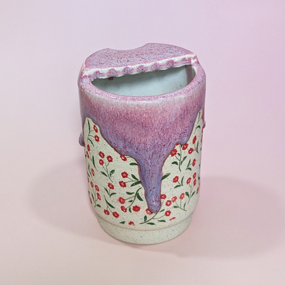 The back of the sippy cup showing long flowing drip of glaze that transitions from a reddish pink to a purple color.