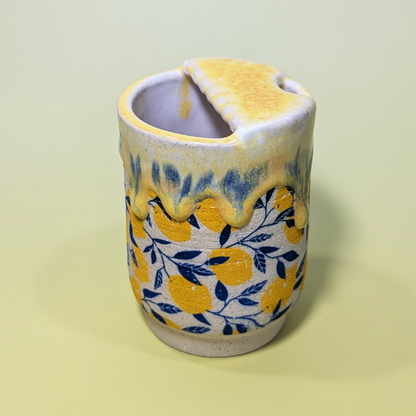 Another view showing the scalloped edge of the lid. The yellow glaze drips and smears the blue leaf pattern beneath it.