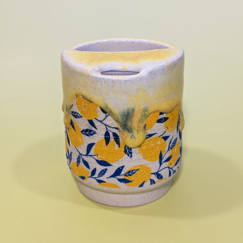 A front facing view of the sippy cup showing the lid and whole to drink from.