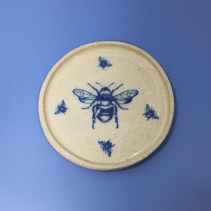 A top view of the trinket dish with a large blue bee in the middle surrounded by four small bees.