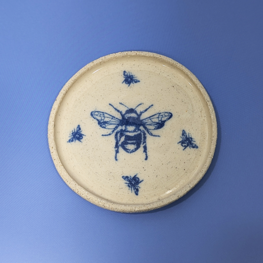 A top view of the trinket dish with a large blue bee in the middle surrounded by four small bees.